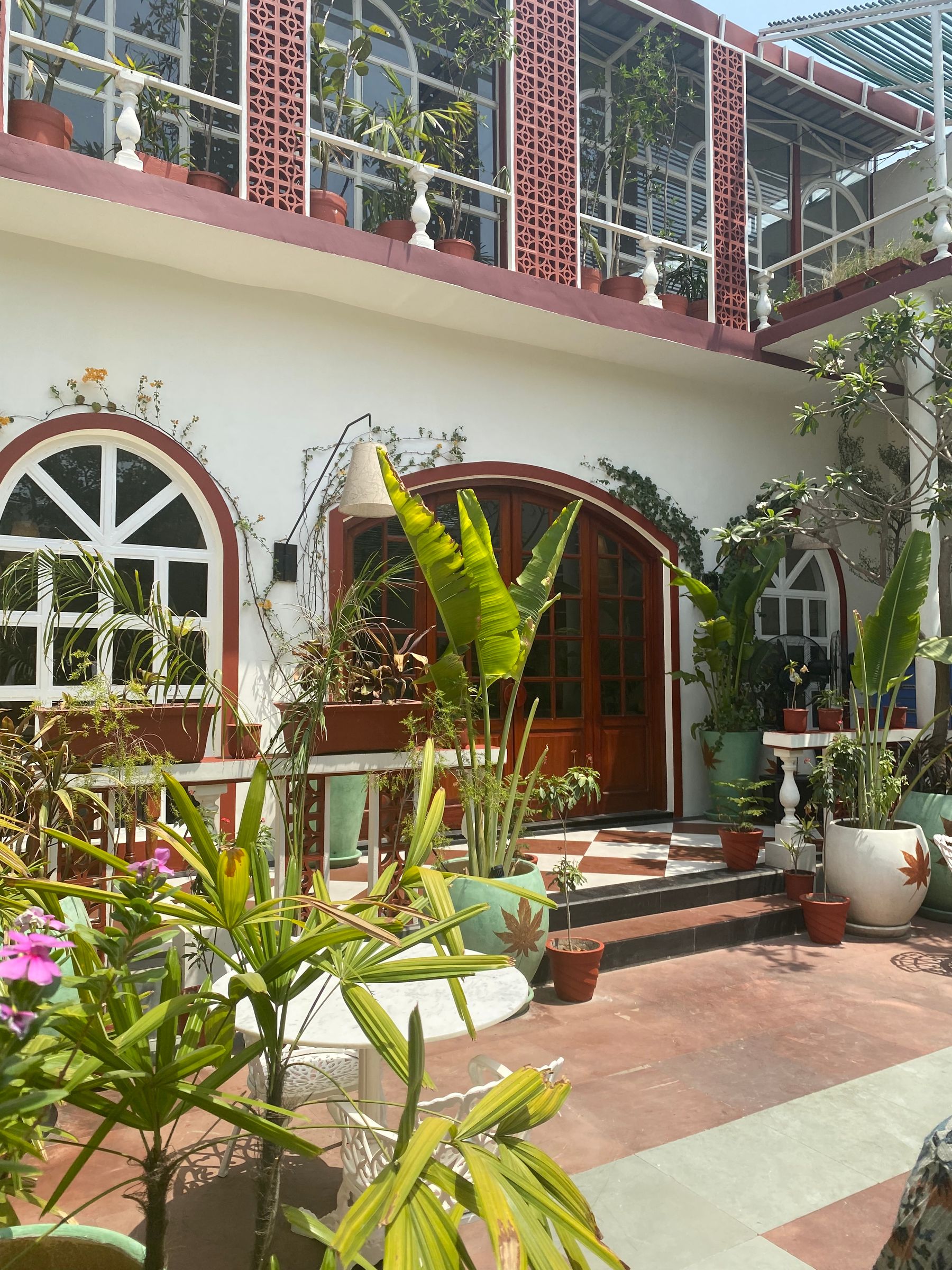 A brick and plaster courtyard with mature tropical planting